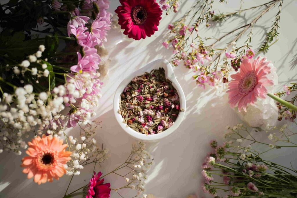 Dried flowers in a bowl surrounded by fresh blooms