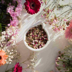 Dried flowers in a bowl surrounded by fresh blooms