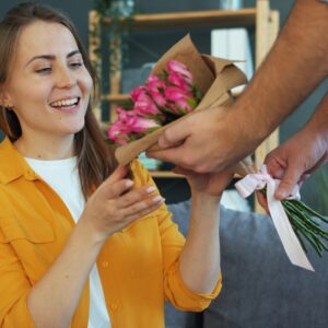 The woman accepted a bouquet of red roses and smiled happily.
